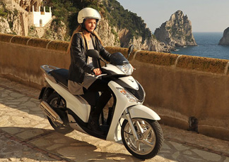 Nella foto la famosa top model californiana Tori Praver, ospite dal 27 dicembre al 2 gennaio del Capri Hollywood, in sella al nuovo scooter Honda SHi