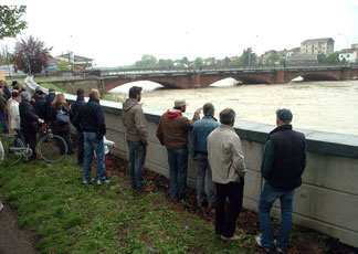 Alcuni cittadini osservano il fiume Tanaro che a causa del maltempo ha innalzato il livello delle acque, ad Alessandria (Ansa)