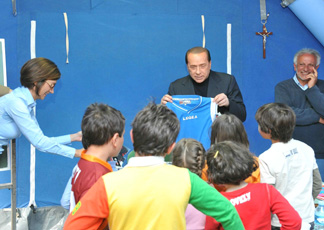 Mariastella Gelmini e Silvio Berlusconi con gli alunni della scuola in tendopoli di Poggio Picenze (Ansa)