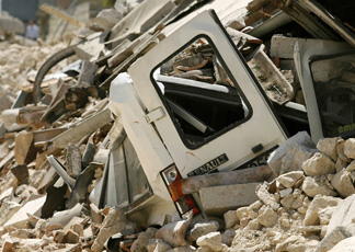 Un furgoncino distrutto dalle macerie a Onna (Reuters)