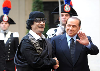 Il presidente del Consiglio dei Silvio Berlusconi accoglie nel cortile di palazzo Chigi, a Roma, il leader libico Muammar El Gheddafi (Ansa/Claudio Onorati)