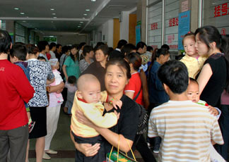 Famiglie cinesi portano i bambini ad un controllo dopo lo scandalo del latte avvelenato nella provincia dello Xian.(AFP PHOTO)