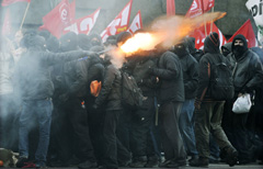 Alcuni manifestanti lanciano razzi contro la polizia (Afp)