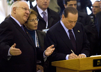 Reuven Rivlin con accanto Silvio Berlusconi mentre firma il libro ospiti durante una cerimonia a Gerusalemme (Epa)